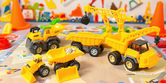 Colorful construction truck toys on a play mat.