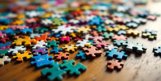 Colorful puzzle pieces scattered on a wooden table.