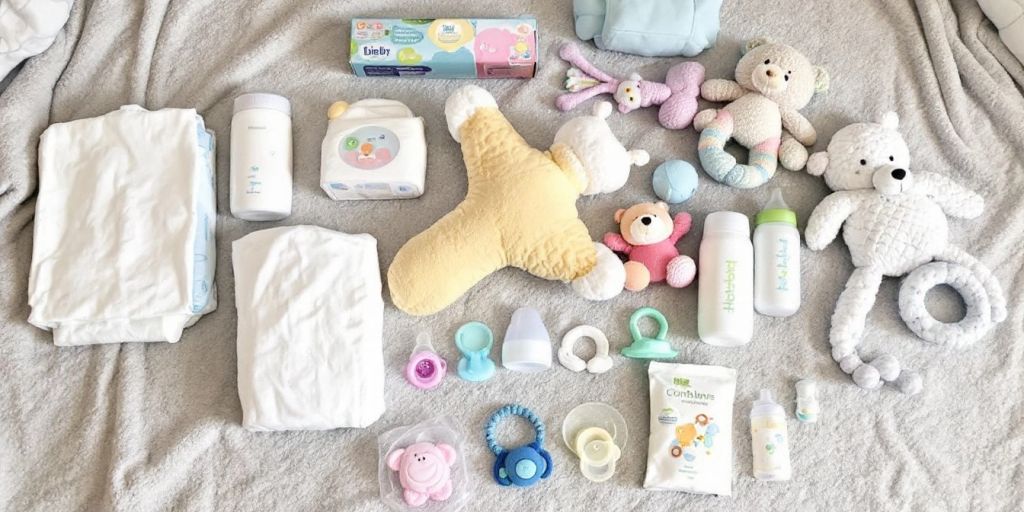 Essential baby items like diapers and bottles on blanket.