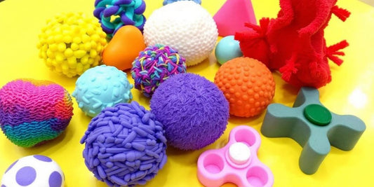 Colorful sensory toys on a bright surface.