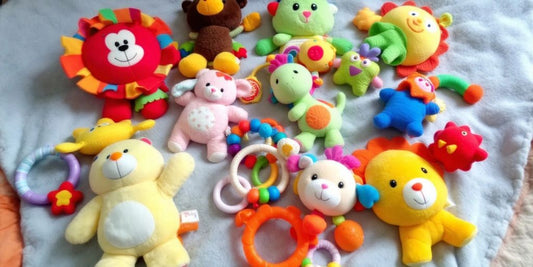 Colorful infant car toys on a soft blanket.